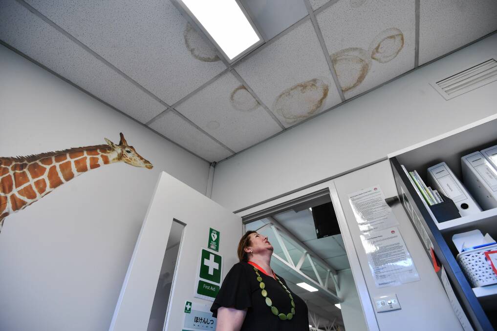 Victoria Lemmer, a parent at Kingswood Primary School, inspects a leaky roof in the first-aid room Photo: Joe Armao
