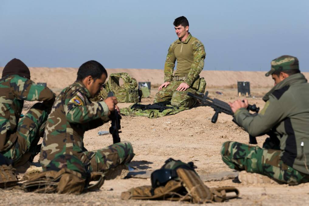 Australian soldier Corporal Emmette Taylor teaches Iraqi personnel how to strip an assault rifle at the Taji military complex. Photo: CPL Kyle Genner
