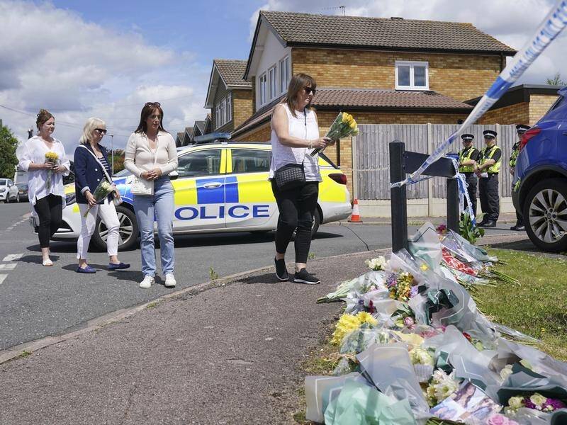 People have left floral tributes following the killing of the mother and her two daughters. (AP PHOTO)