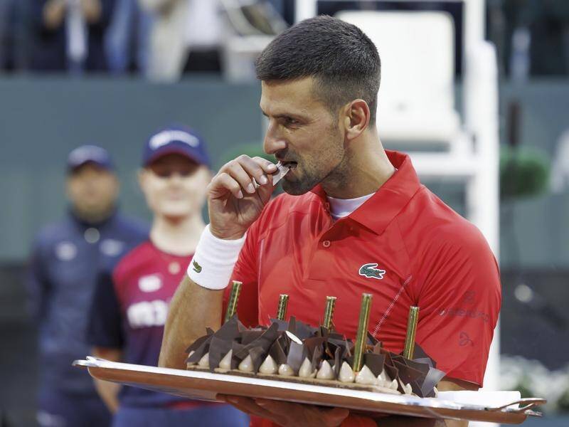 Novak Djokovic has a nibble of his birthday cake after beating Yannick Hanfmann in Geneva. (AP PHOTO)