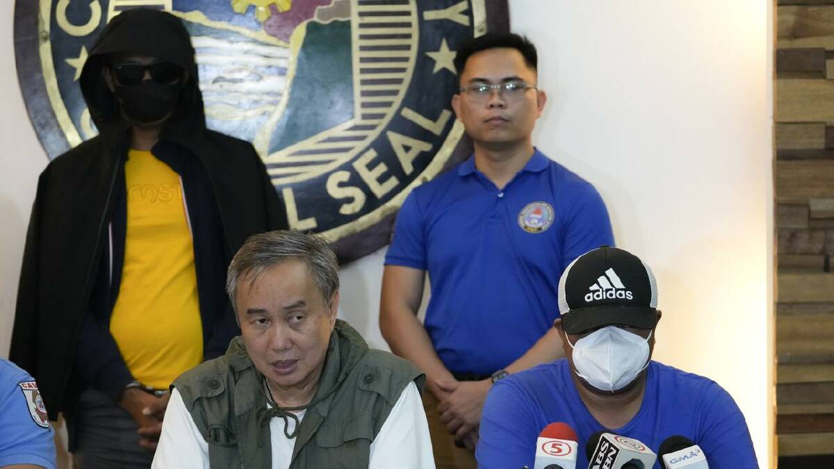 The suspect (left) was shown at a press briefing with Tagaytay Mayor Abraham Tolentino (second left) (AP PHOTO)