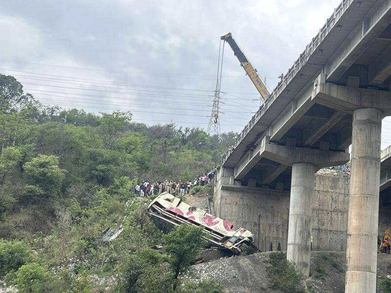 A bus carrying Hindu pilgrims to a shrine skidded off a highway bridge into a gorge. (AP PHOTO)