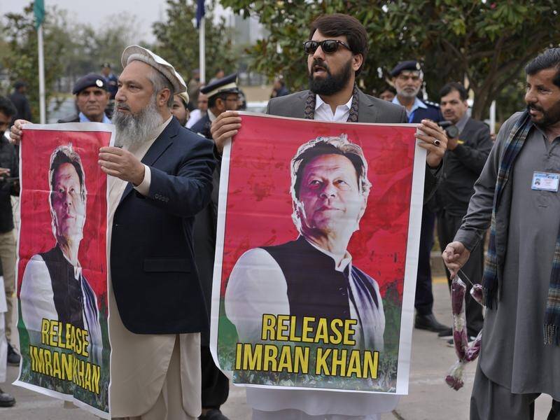 MPs have waved posters of their jailed leader Imran Khan as they arrived at parliament. (AP PHOTO)