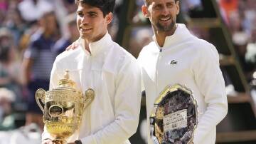 Young Spanish gun Carlos Alcaraz holds the Wimbledon winner's trophy alongside Novak Djokovic. (AP PHOTO)