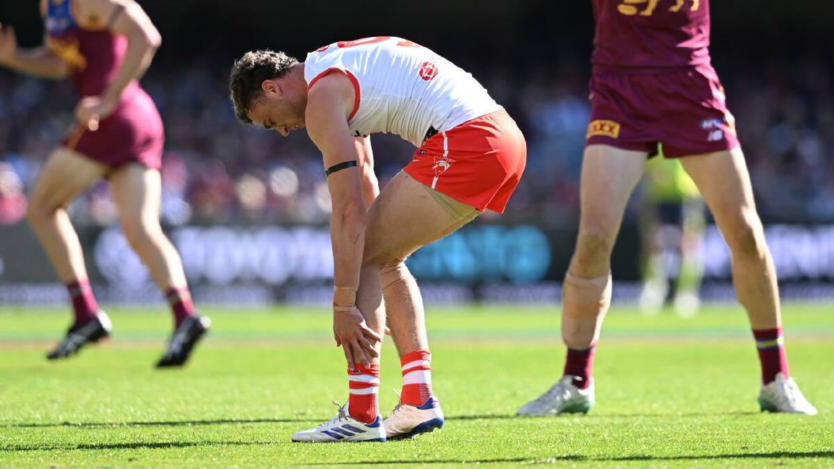 Will Hayward reaches for his left ankle during the Swans' tight loss to the Lions. (Darren England/AAP PHOTOS)