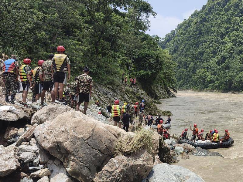 Nepalese army personnel look for survivors after two buses were swept into a river by a landslide. (AP PHOTO)