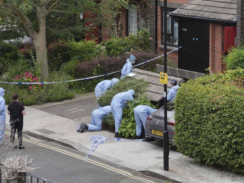 Forensic officers examine a west London address after human remains were found in two suitcases. (AP PHOTO)