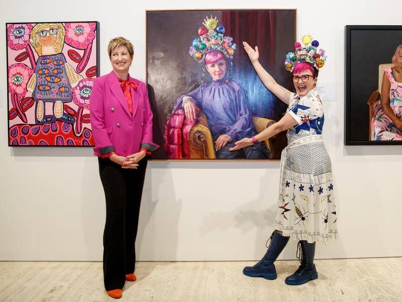 Artist Andrea Huelin (left) and comedian Cal Wilson with the Archibald Packing Room Prize portrait. (Nikki Short/AAP PHOTOS)