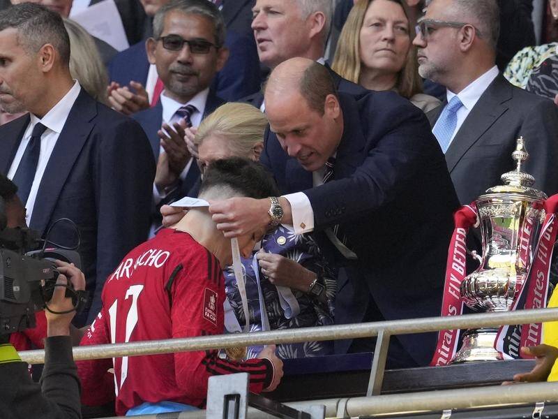 Manchester United's Alejandro Garnacho receives his FA Cup winner's medal from Prince William. (AP PHOTO)