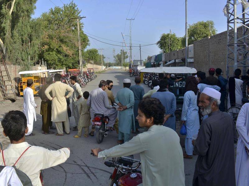 Residents gather at a barricaded road in Bannu after a suicide bombing outside a military facility. (AP PHOTO)