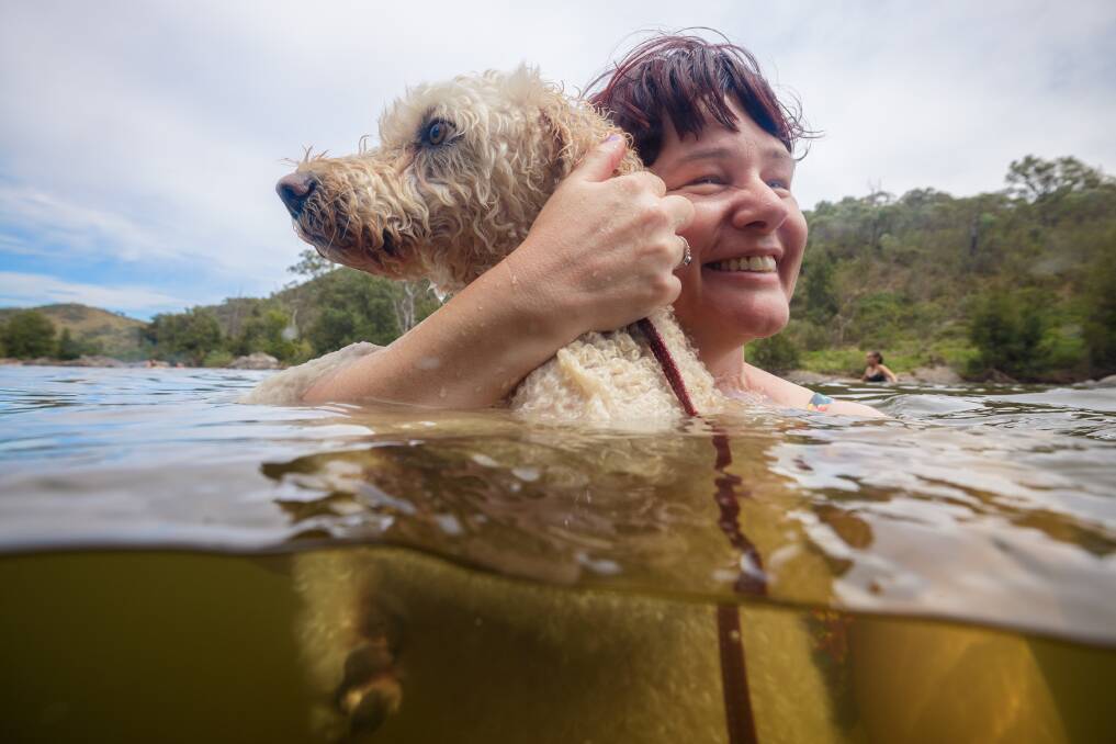 Peta Jane Blessing from Hackett and her labradoodle Belle joined dozens of other Canberrans at Uriarra East Reserve on Sunday for a cooling dip. Picture by Sitthixay Ditthavong