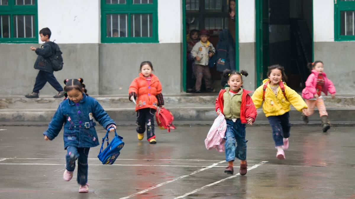 Children run across the playground at a primary school in Fuli, Guangxi. Picture: Getty Images