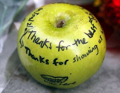 An apple with tributes written on it forms part of a memorial for Steve Jobs in Boston.